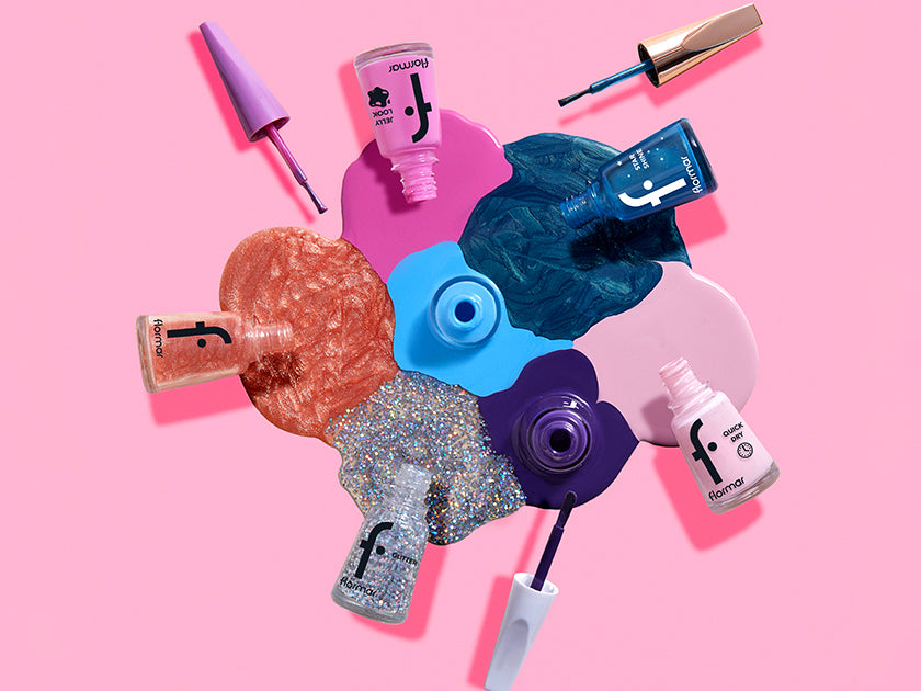 Flormar nail polish collection in glittery, metallic, and vibrant shades, displayed with colorful paint splashes on a pink background.